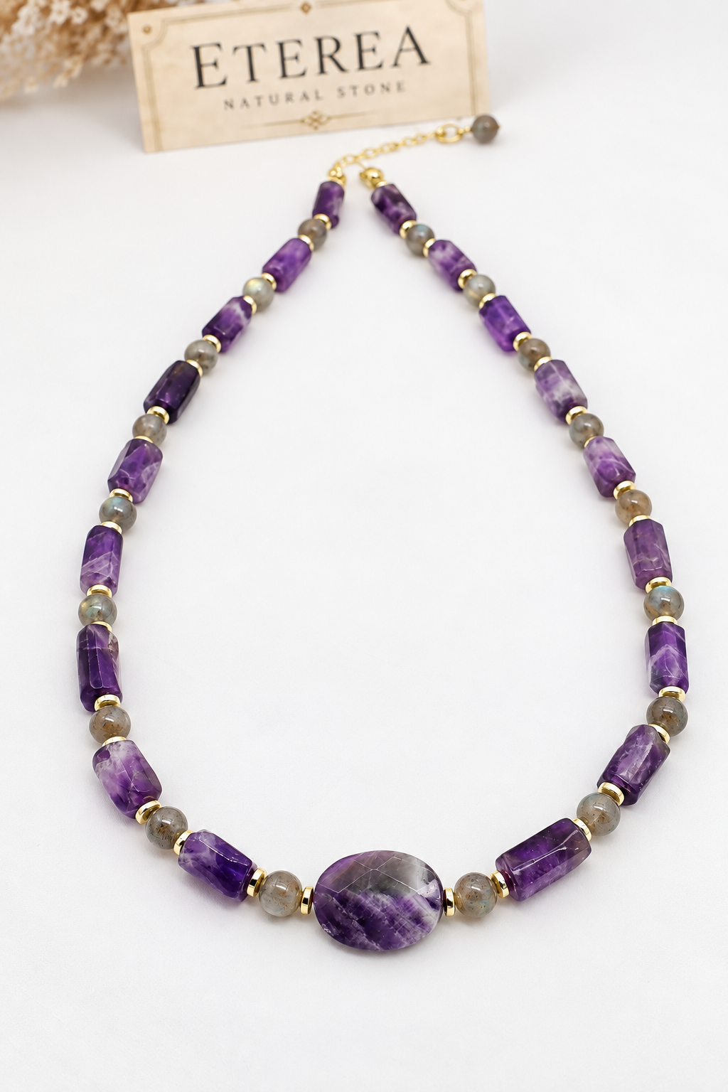 Collana girocollo in ametista naturale sfaccettata e labradorite con distanziatori in ematite dorata, elemento centrale ovale in ametista e chiusura in acciaio dorato.