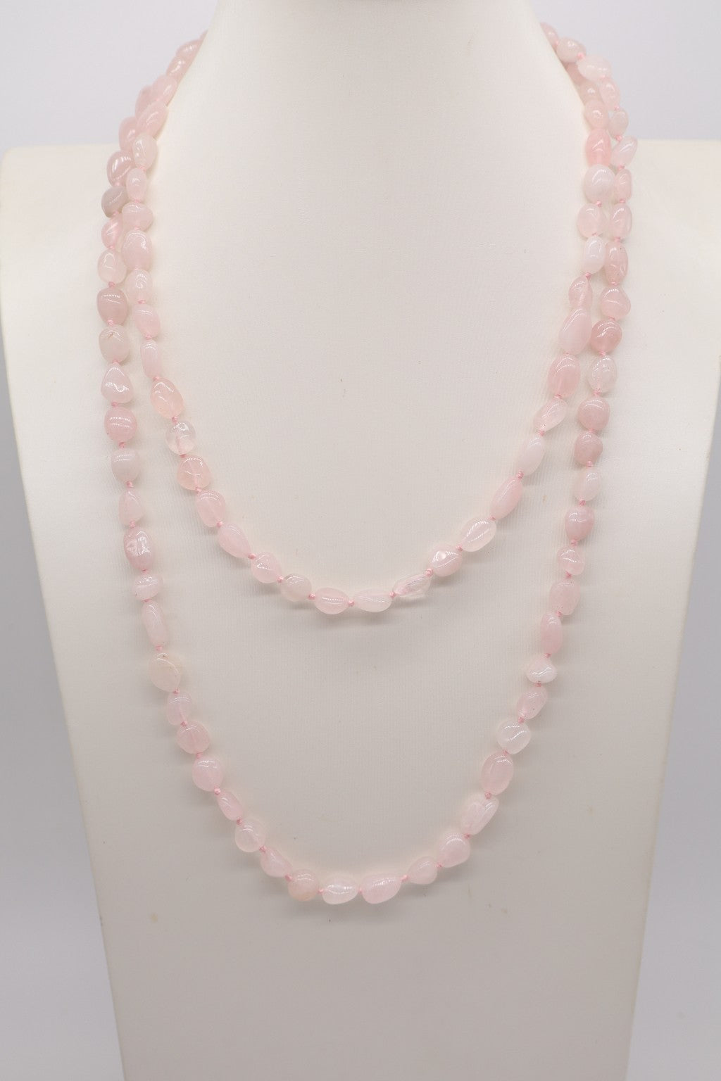 Collana lunga 120 cm in quarzo rosa, annodata a mano con filo rosa, fotografata sul busto per mostrare la vestibilità e la lunghezza.