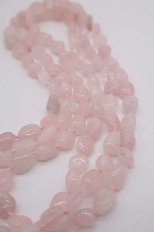 Dettaglio delle pepite burattate di quarzo rosa naturale, con forme organiche e delicate sfumature rosa, nella collana Essential Eterea.