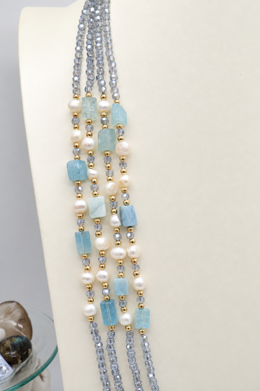Collana multifilo azzurra da 90 cm con cristalli sfaccettati, acquamarina rettangolare da circa 12 × 8 mm, perle semi-round da 5 mm e distanziatori dorati.