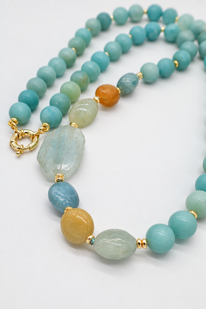 Collana Prestige Eterea in Amazzonite naturale da 12 mm e Acquamarina naturale, con grande Acquamarina irregolare da 35 × 20 mm e chiusura in Argento 925 dorato.