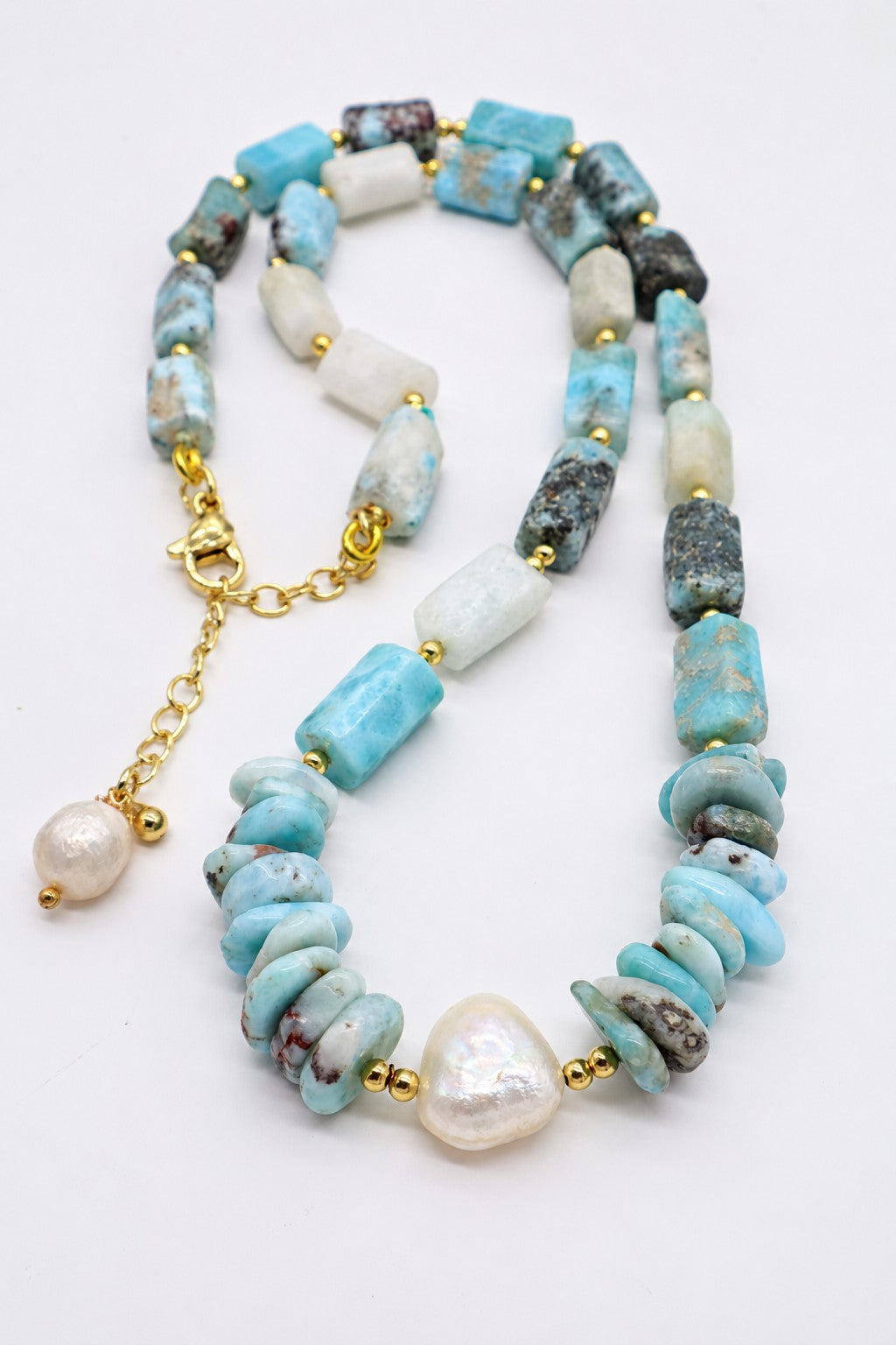 Collana girocollo in larimar naturale e perle di fiume con dettagli dorati, chiusura in acciaio dorato e lunghezza regolabile 45–50 cm.