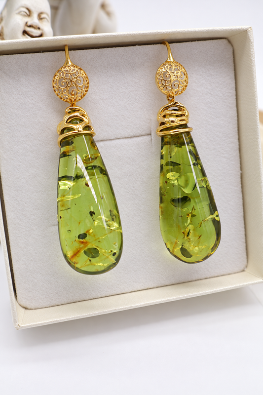 Dettaglio degli orecchini Eterea in argento dorato e ambra verde colombiana con grandi gocce trasparenti e inclusioni naturali