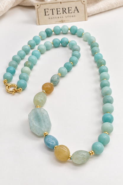 Collana Prestige Eterea in Amazzonite naturale da 12 mm e Acquamarina naturale, con grande Acquamarina irregolare da 35 × 20 mm e chiusura in Argento 925 dorato.