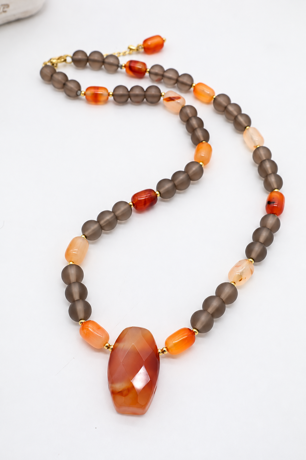 Collana girocollo in agata grigia matte e corniola naturale rosso-arancio, con chiusura in acciaio dorato.