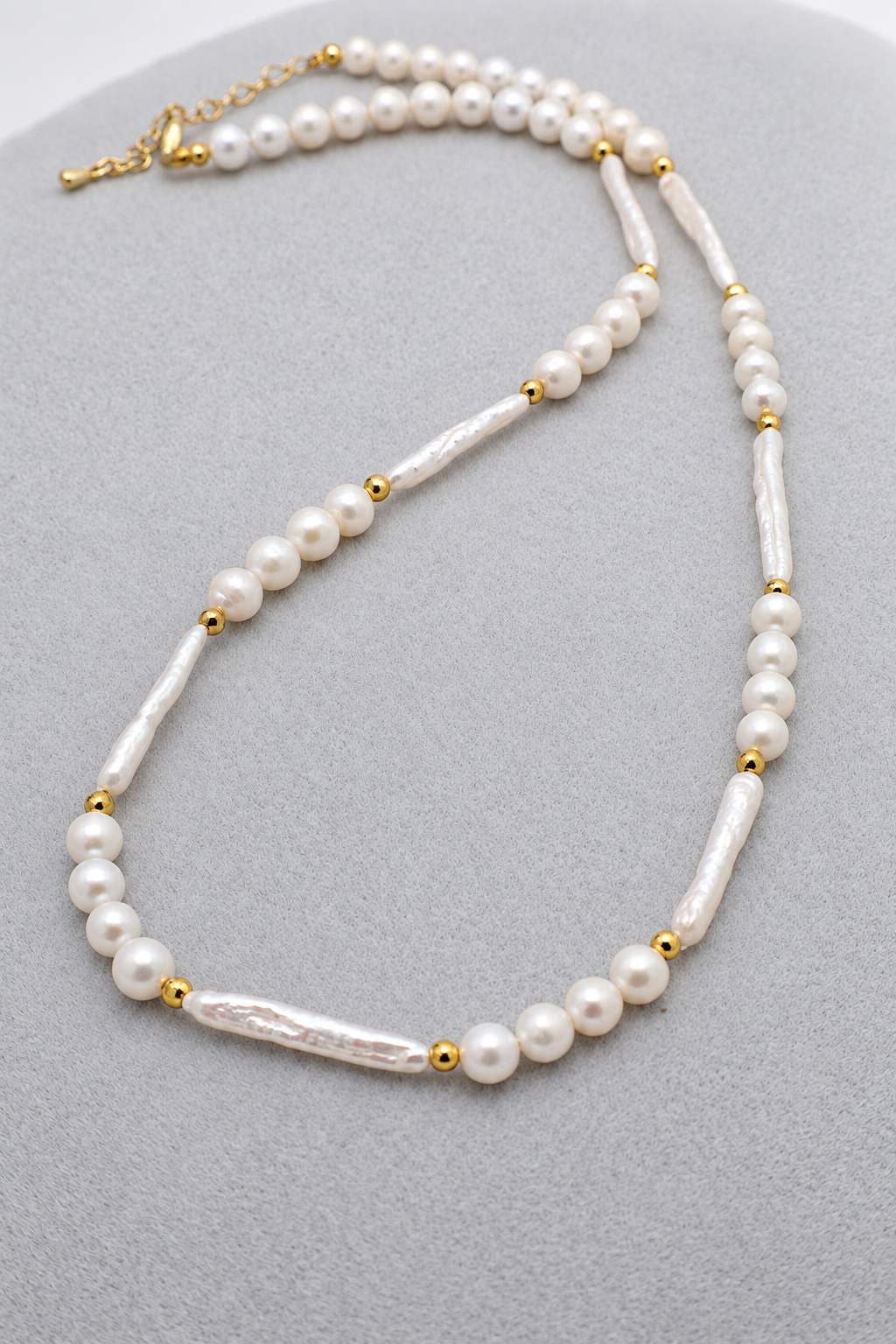Collana girocollo in perle di fiume sferiche e allungate, con dettagli dorati e chiusura con moschettone