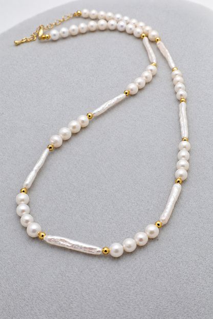 Collana girocollo in perle di fiume sferiche e allungate, con dettagli dorati e chiusura con moschettone