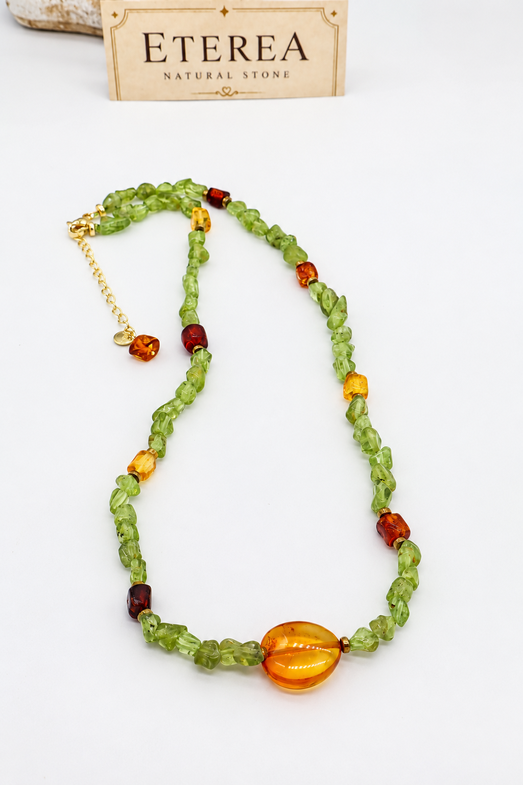Girocollo in peridoto naturale e ambra baltica con pepite irregolari verdi da circa 3 mm, inserti in ambra gialla e marrone, distanziatori in ematite color bronzo e chiusura in acciaio con prolunga di 5 cm.