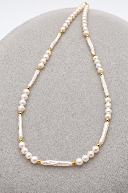 Collana girocollo in perle di fiume sferiche e allungate, con dettagli dorati e chiusura con moschettone