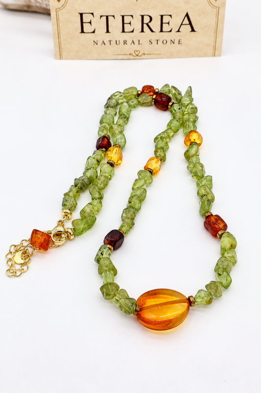 Girocollo in peridoto naturale e ambra baltica con pepite irregolari verdi da circa 3 mm, inserti in ambra gialla e marrone, distanziatori in ematite color bronzo e chiusura in acciaio con prolunga di 5 cm.