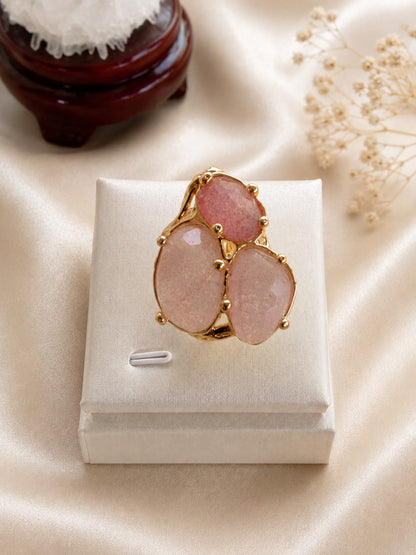 Anello regolabile in metallo dorato galvanizzato con tre pietre naturali sfaccettate in quarzo rosa fragola.