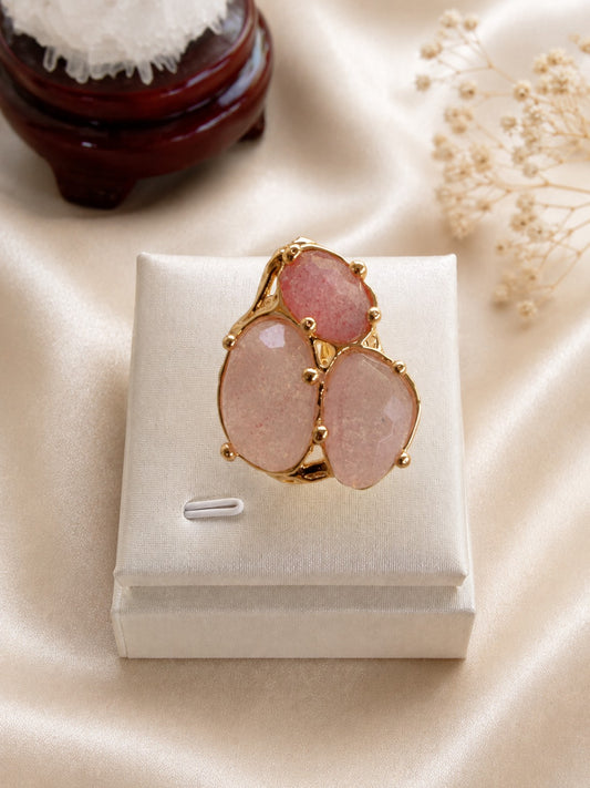 Anello regolabile in metallo dorato galvanizzato con tre pietre naturali sfaccettate in quarzo rosa fragola.