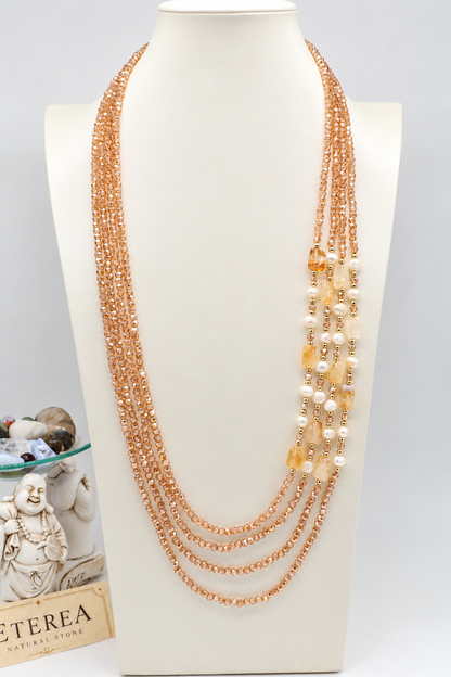Collana multifilo da 90 cm con cinque fili di cristalli sfaccettati color champagne da 3 mm, citrino rettangolare da 14 × 10 mm, perle semi-round da 5 mm e distanziatori dorati.
