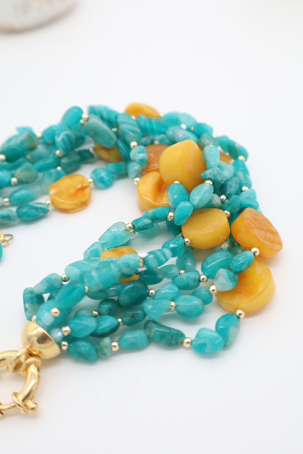 Dettaglio bracciale in amazzonite sfumata e dischi di ambra color miele
