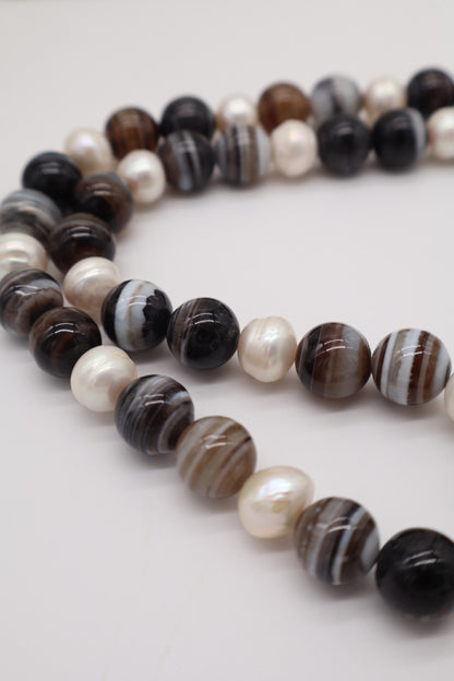 Dettaglio collana in agata fasciata e perle barocche, con venature naturali dell'agata e forme irregolari delle perle
