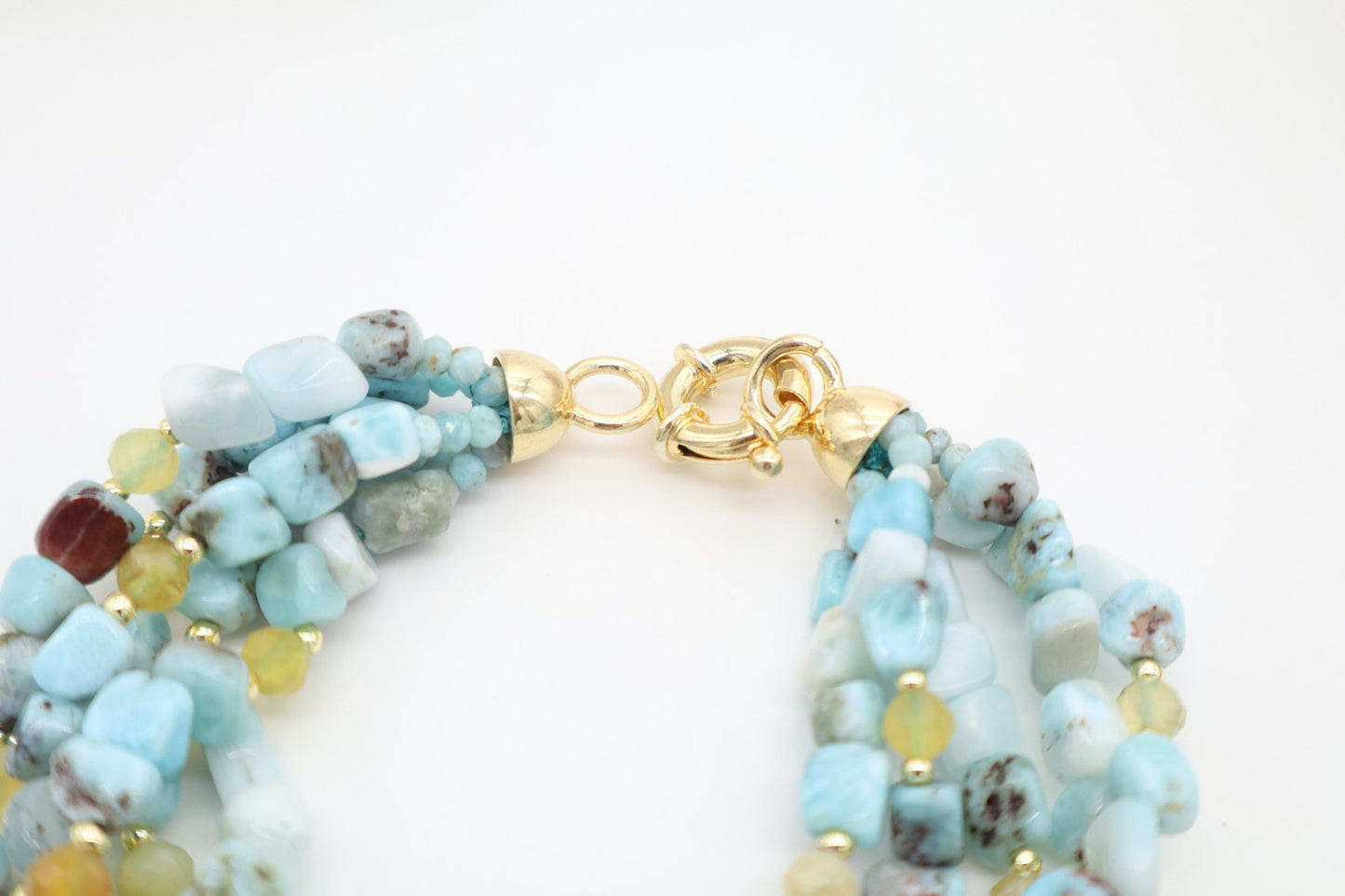 Dettaglio della chiusura in argento dorato del bracciale multifilo in Larimar, Opale ed Ematite