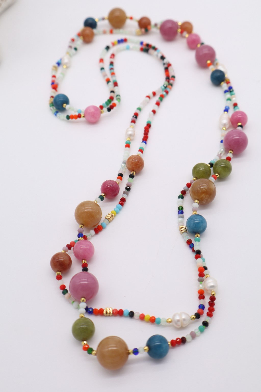 Dettaglio della collana Essential in giada multicolore e cristalli sfaccettati colorati, con perle di fiume e dettagli dorati, Eterea Natural Stone.