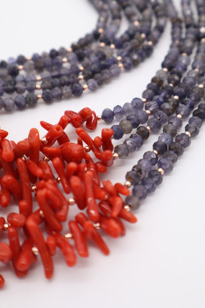 Dettaglio di collana elegante in iolite sfaccettata e corallo rosso naturale con distanziatori dorati