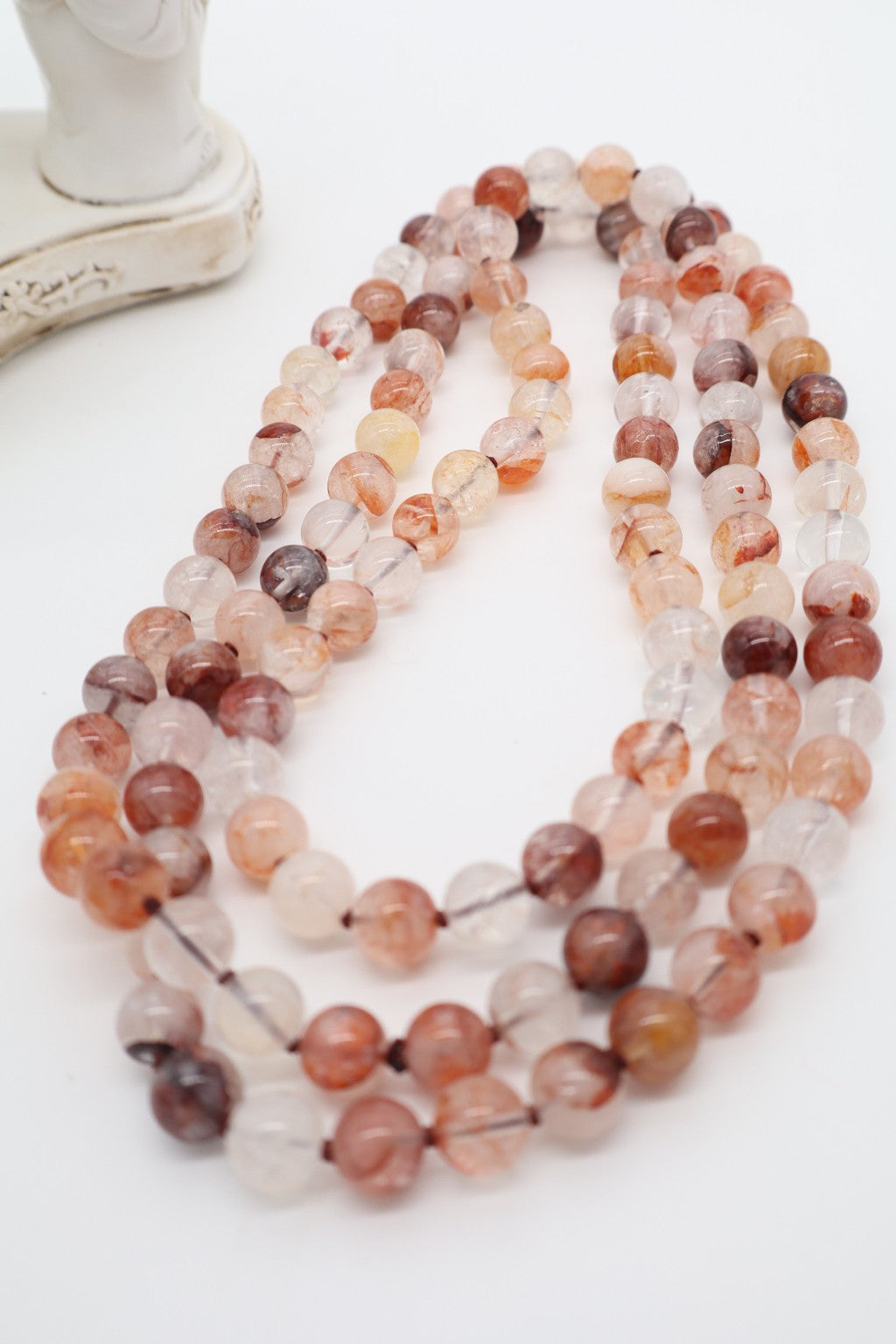 Immagine 1: Collana lunga 120 cm in quarzo ematoide naturale con sfere traslucide nelle tonalità pesca, arancio, rosso e bruno, interamente annodata.