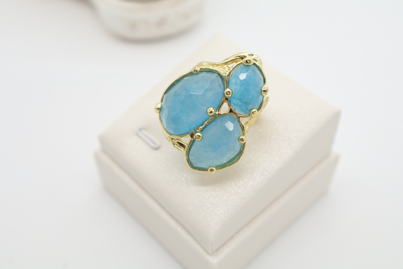 Immagine 2: Anello in bronzo dorato galvanizzato con giada celeste sfaccettata visto lateralmente