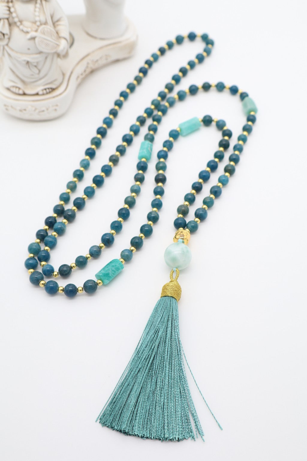 Mala Mettā in Apatite blu da 7 mm, Amazzonite, ematite dorata e guru in Larimar da 12 mm con nappina verde ottanio