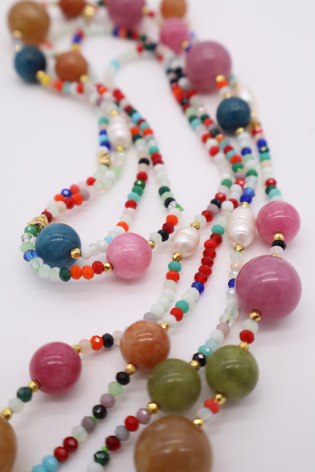 Particolare ravvicinato della collana lunga in giada multicolore, cristalli da 3 mm e piccole perle di fiume, con distanziatori dorati, Eterea Natural Stone.