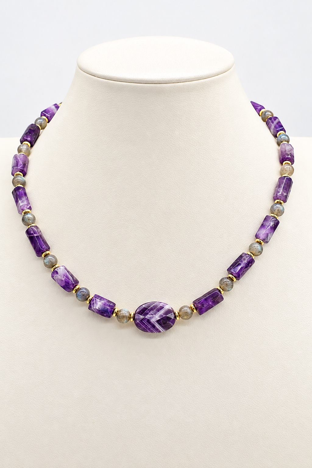 Collana girocollo in ametista naturale sfaccettata e labradorite con distanziatori in ematite dorata, elemento centrale ovale in ametista e chiusura in acciaio dorato.
