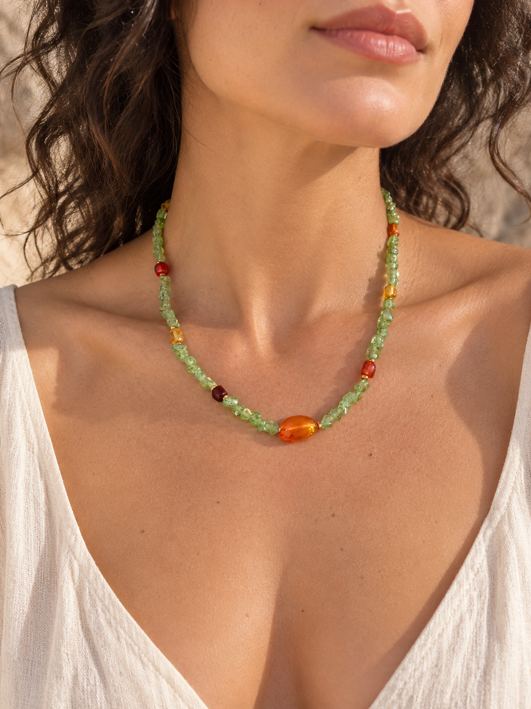 Girocollo in peridoto naturale e ambra baltica con pepite irregolari verdi da circa 3 mm, inserti in ambra gialla e marrone, distanziatori in ematite color bronzo e chiusura in acciaio con prolunga di 5 cm.