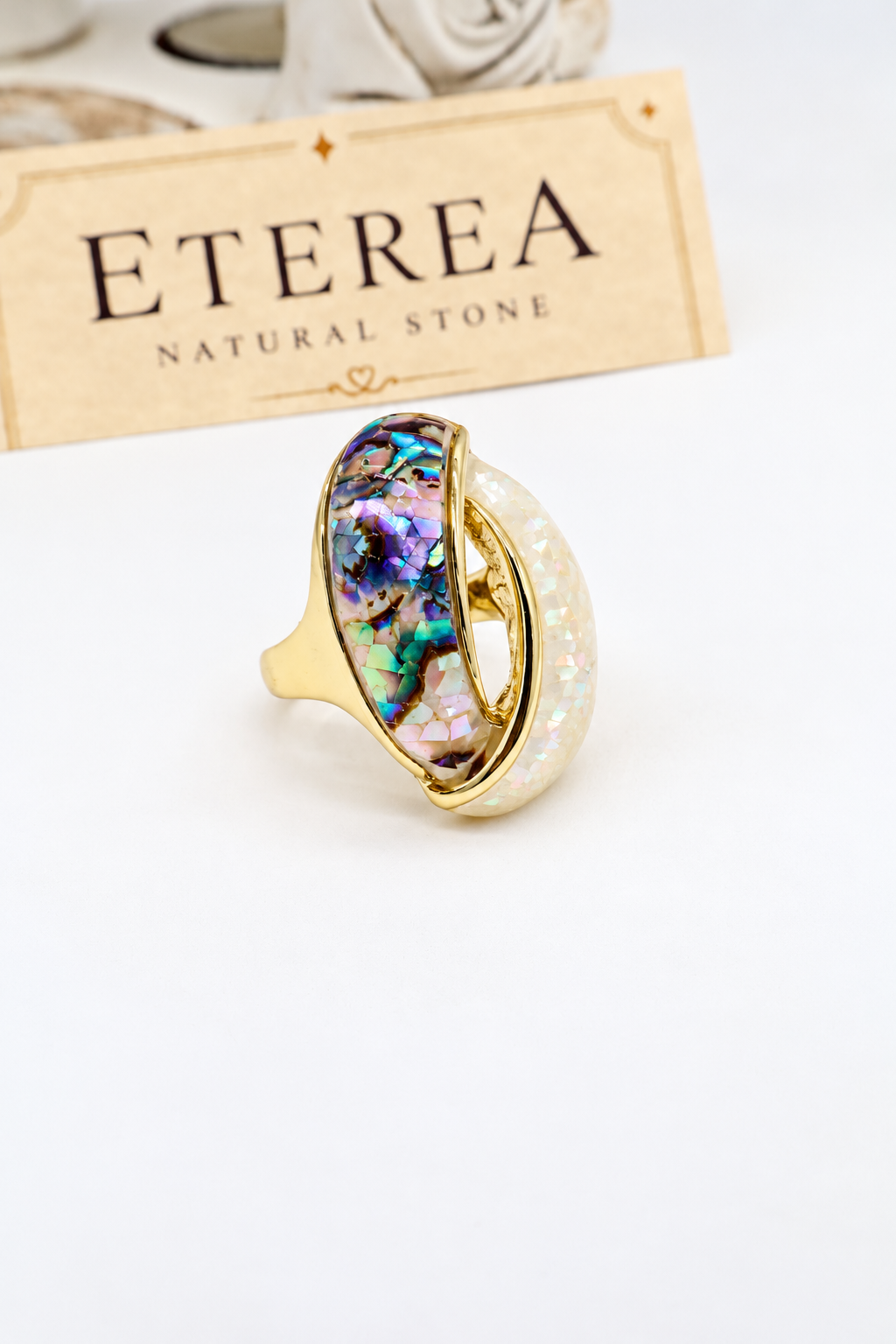 Anello ovale in acciaio dorato con madreperla e abalone, design elegante e iridescente