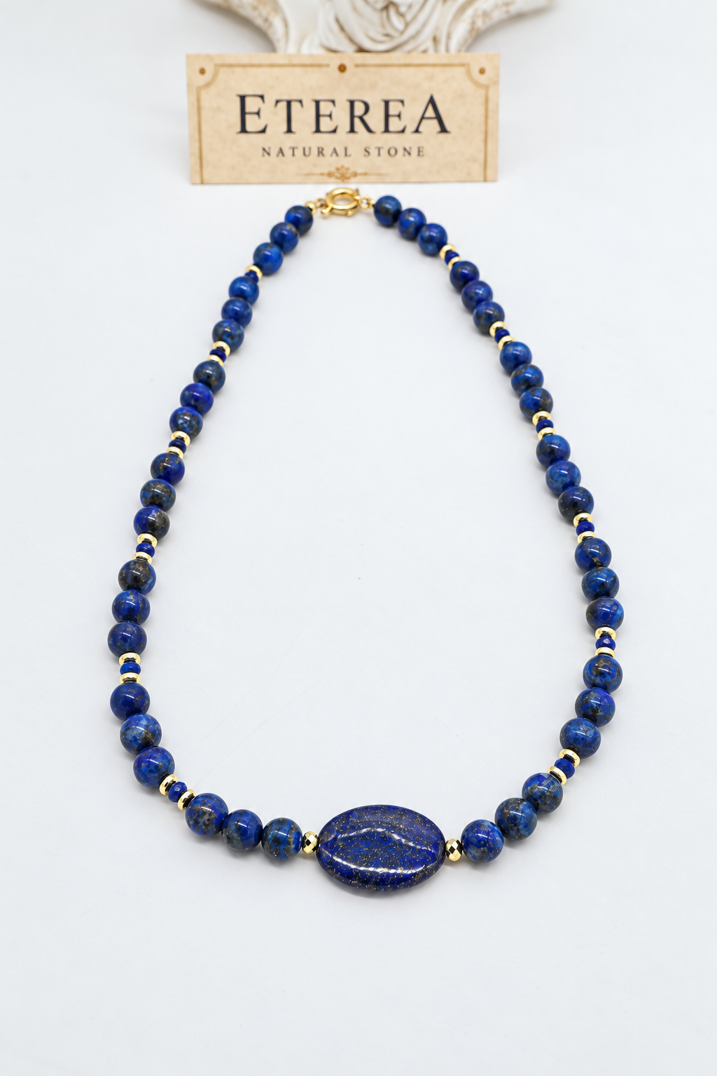 Girocollo in lapislazzuli naturale con sfere blu da 8 mm, pietra ovale centrale 25x15 mm, distanziatori in ematite dorata e chiusura in argento 925 dorato – Eterea Natural Stone