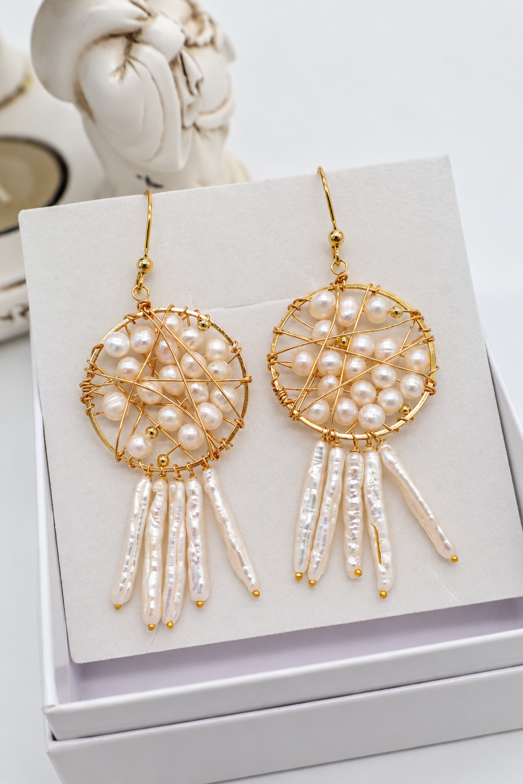 Orecchini pendenti Trama d'Incanto con cerchio in bronzo dorato, perle di fiume allungate e monachella in argento 925 dorato.
