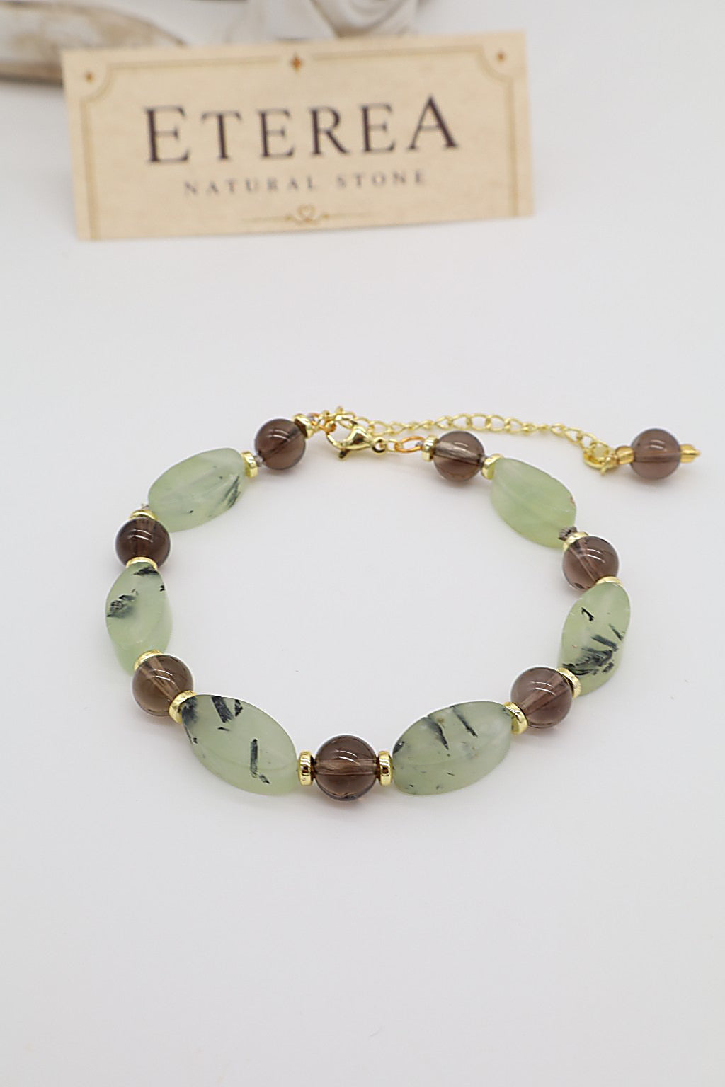 Bracciale in quarzo fumé e prehnite naturale con pietre ovali verde salvia, sfere trasparenti marroni e dettagli dorati, Eterea Natural Stone.