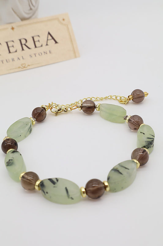 Bracciale in quarzo fumé e prehnite naturale con pietre ovali verde salvia, sfere trasparenti marroni e dettagli dorati, Eterea Natural Stone.